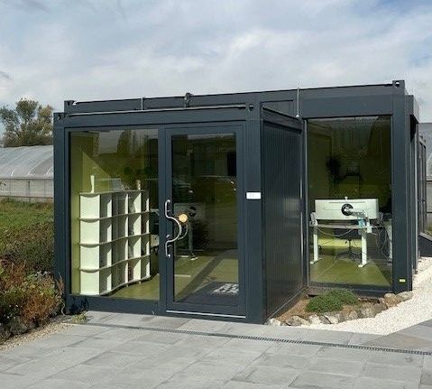 Ein schwarzer Bürocontainer mit Glastüren